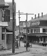 c. 1892-1899. Signs for the "W.C.T.U. Reading Room," "Confectionery," and "Laundry" are all visible on the left, near the barber pole.